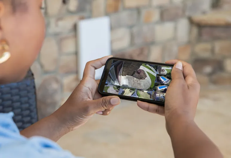 Homeowner viewing multiple security-camera feeds on a mobile phone