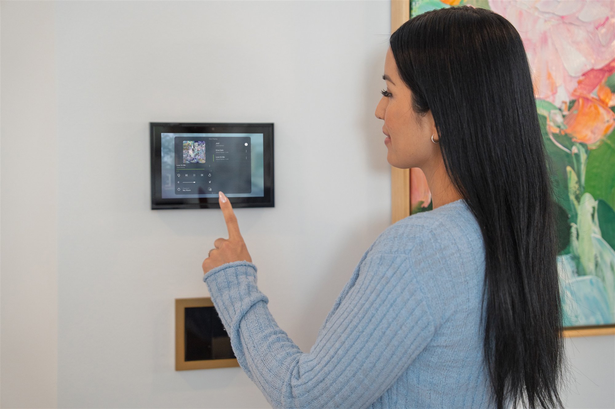 Homeowner using a Control4 wall touchscreen for media control