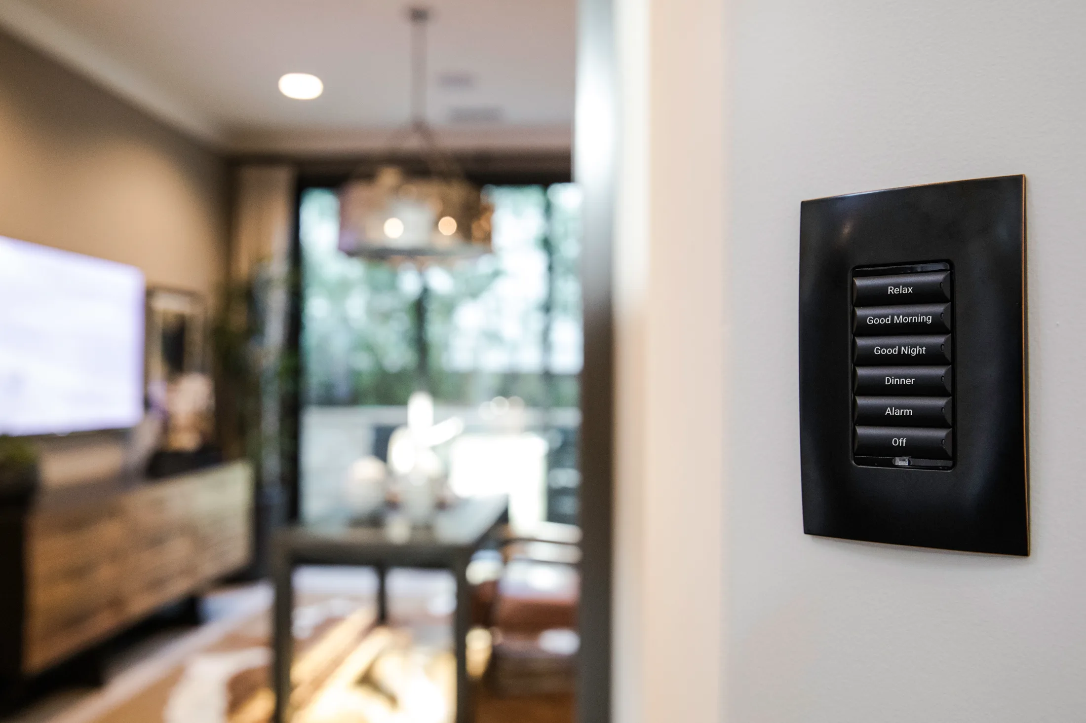Black engraved Control4 keypad installed in a finished living room