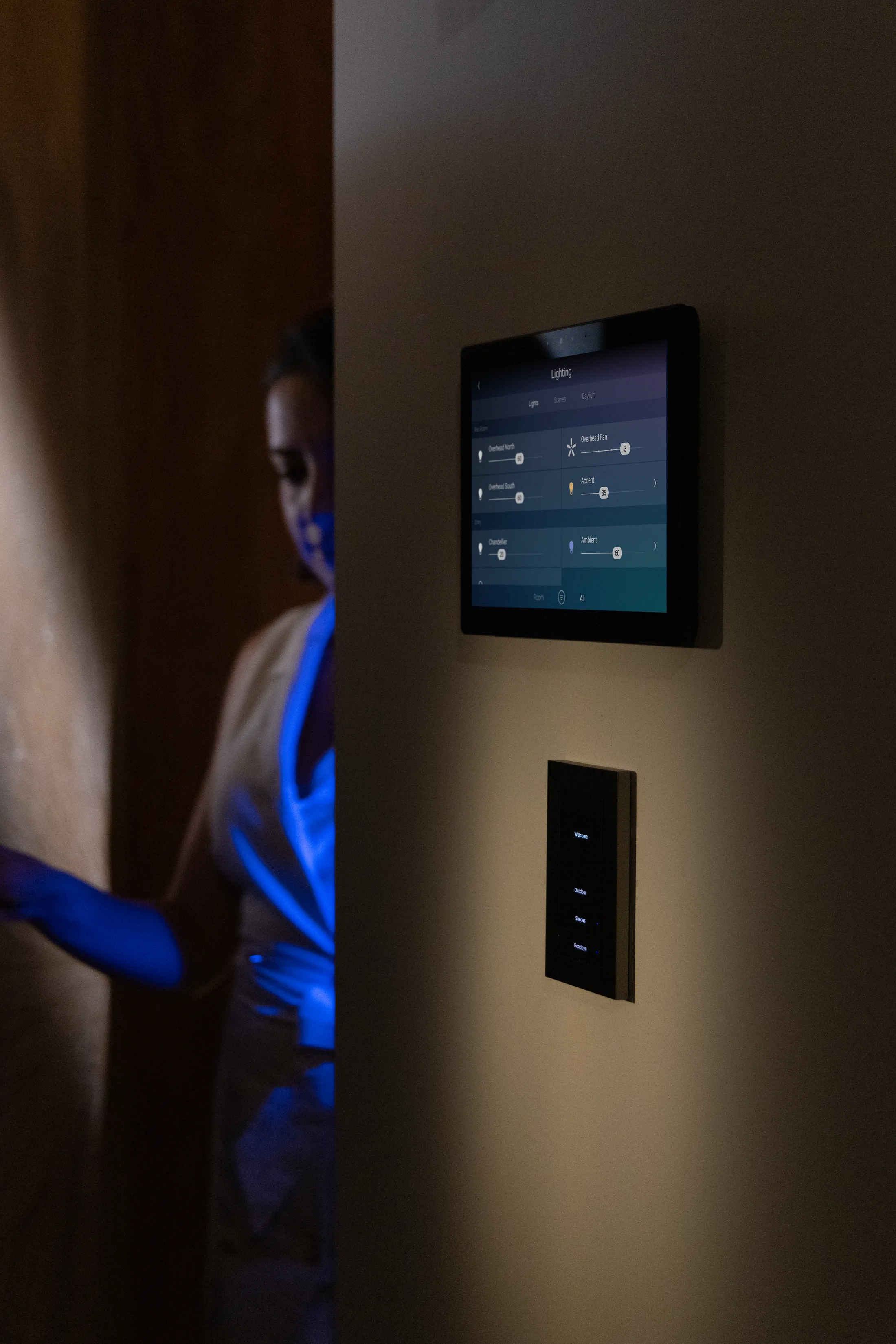 Lux by Control4 keypad installed below a touchscreen in evening light