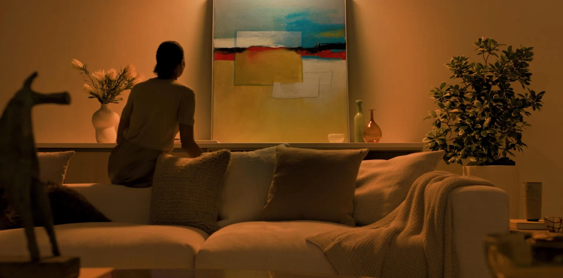 Warm HomeWorks lighting scene illuminating artwork and a modern living room