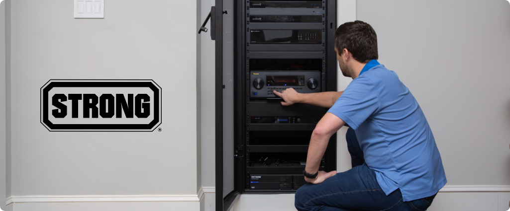 Technician servicing a full-height Strong equipment rack