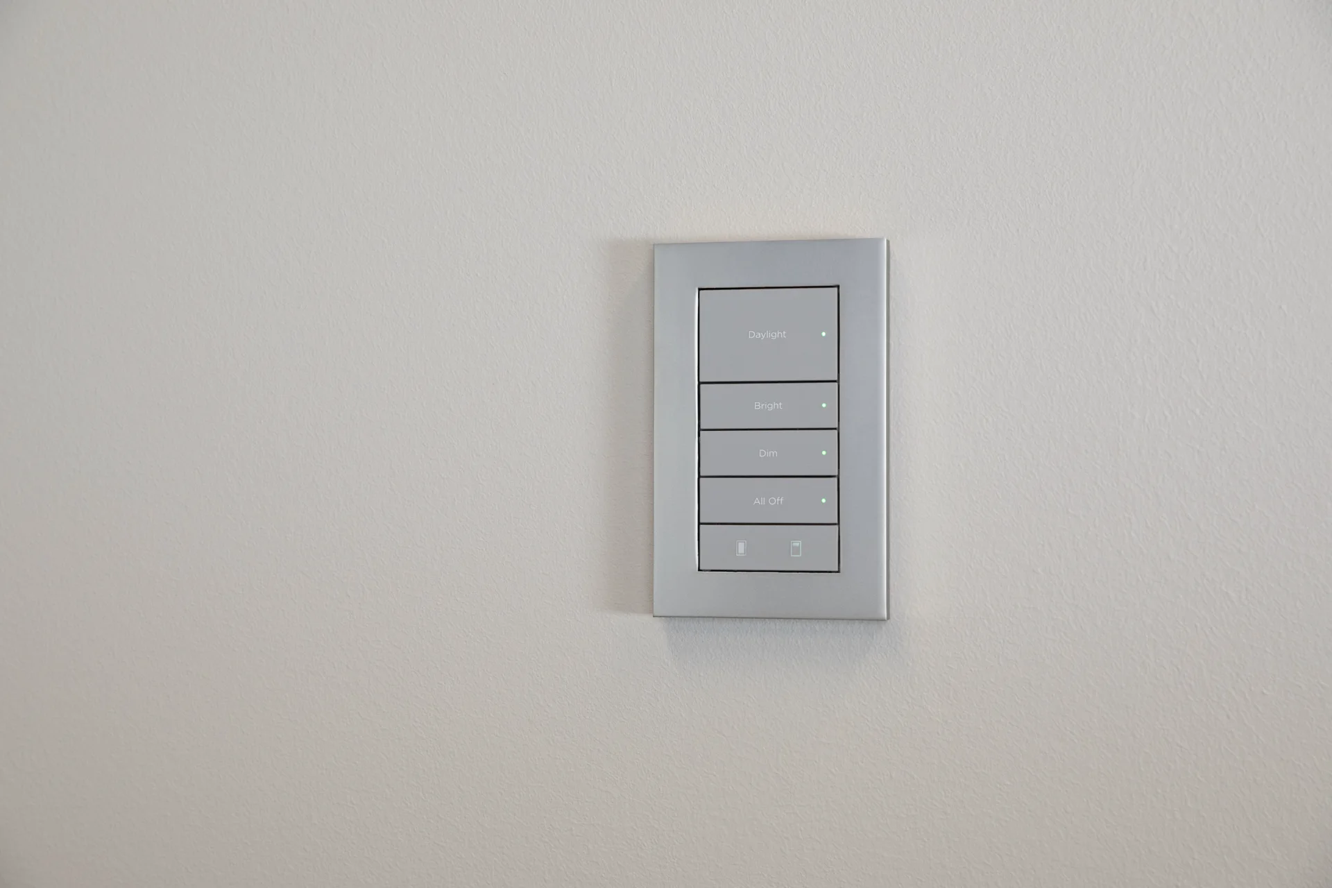Silver Lux by Control4 engraved five-button keypad installed on a light wall