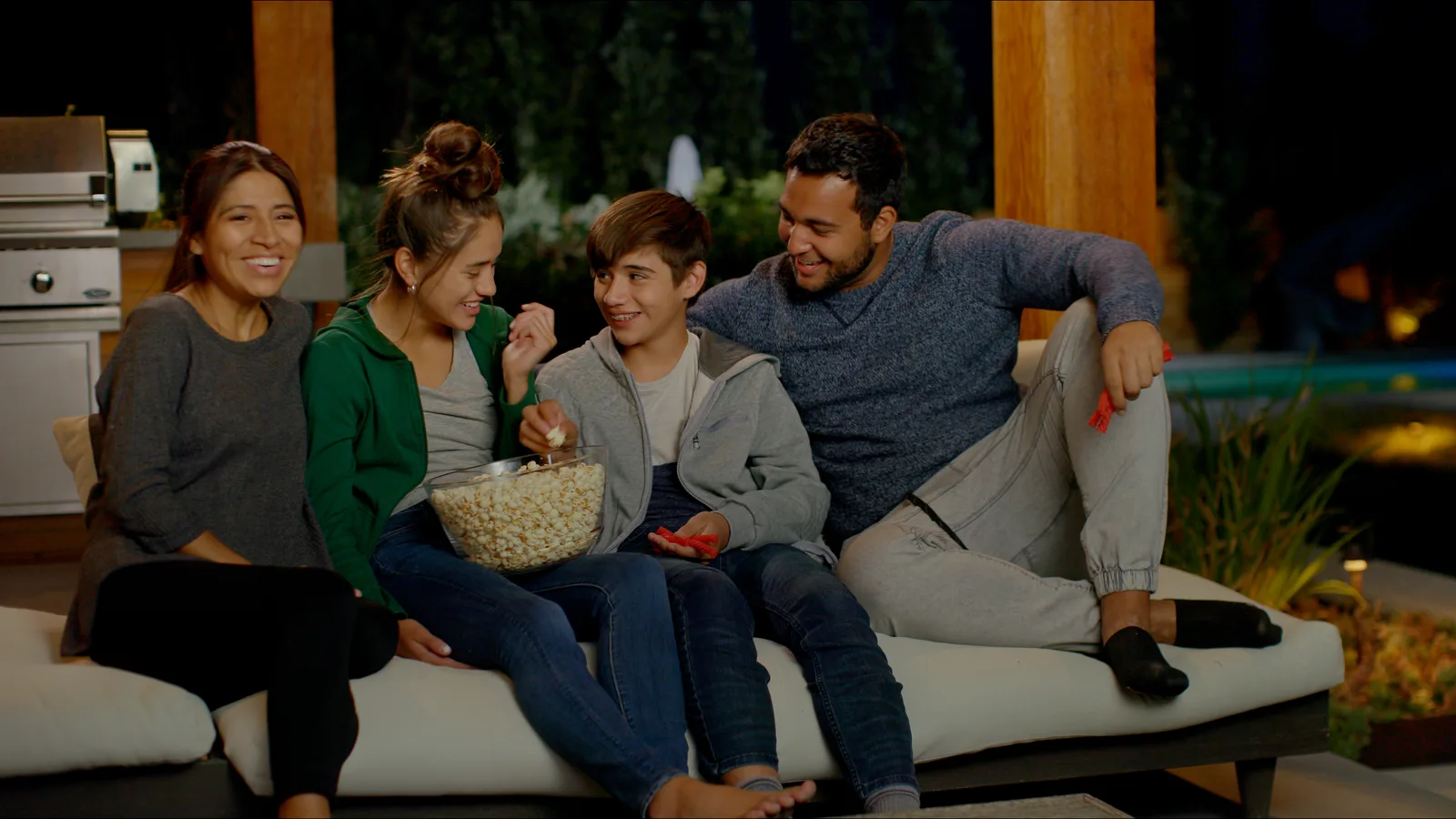 Family enjoying an outdoor entertainment area at night