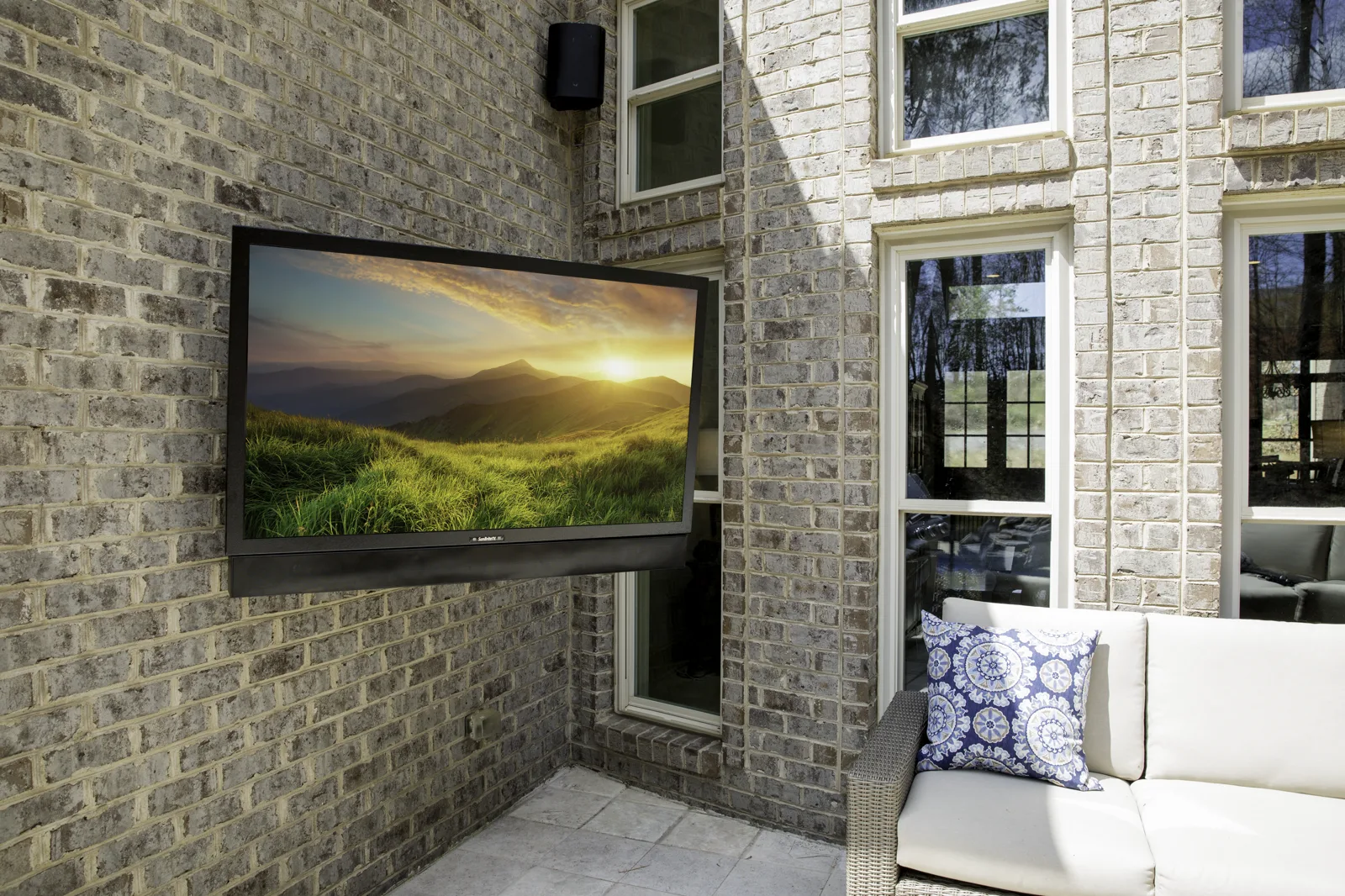SunBrite Pro outdoor television installed on an exterior brick wall