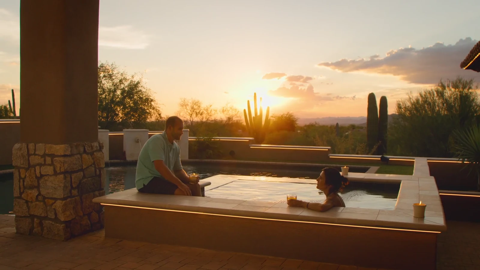 Outdoor pool and patio with warm linear lighting at sunset