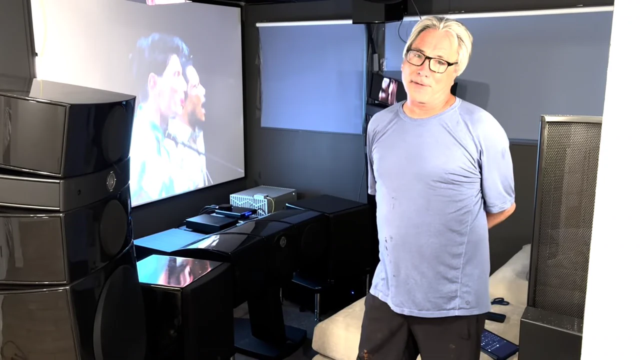 Glenn beside his projection screen and theater speakers