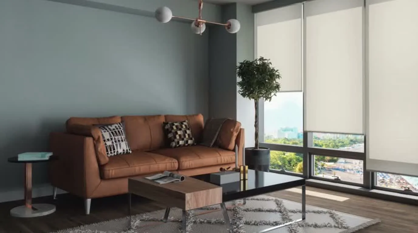 Motorized window shades lowered in a bright living room for privacy and glare control