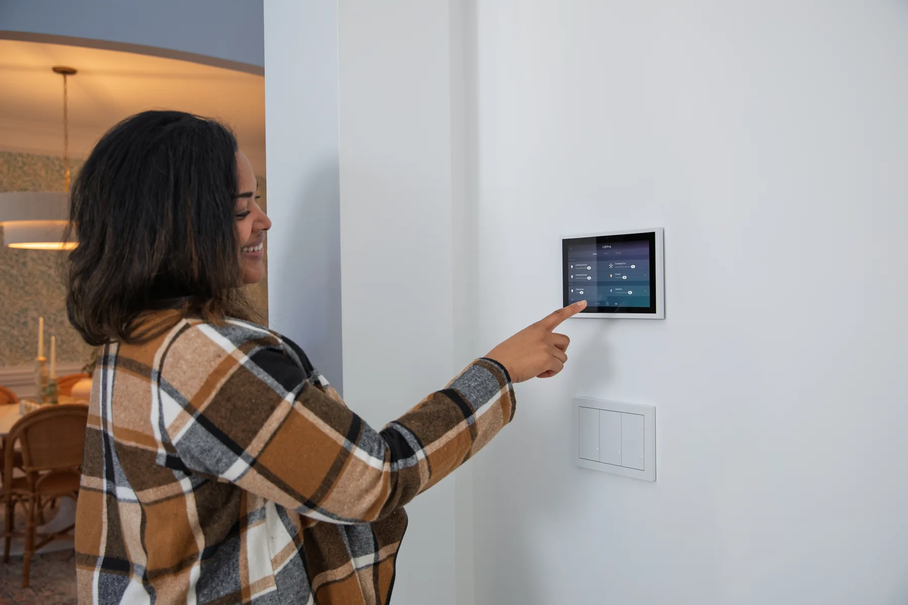 Homeowner adjusting a Control4 lighting scene from a wall touchscreen